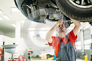 Car service, repair, maintenance and people concept - happy smiling auto mechanic man at workshop