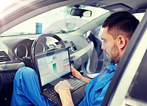 Mechanic man with laptop making car diagnostic