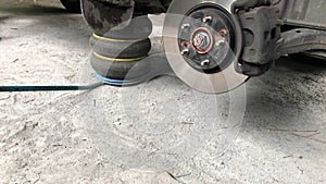 Car service station panning: pneumatic jack, front brake disc with brake pads