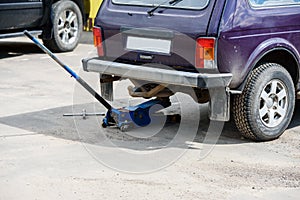 Car at a service station standing on a Jack-wheel replacement.