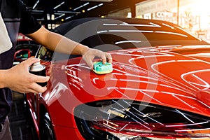 Car service worker applying nano coating on a car detail