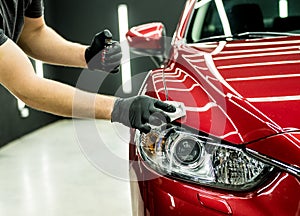 Car service worker applying nano coating on a car detail.