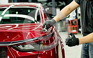 Car service worker applying nano coating on a car detail. photo