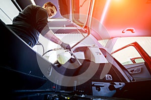 A car service worker cleans interiror with a special foam generator