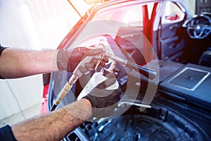 A car service worker cleans interiror with a special foam generator