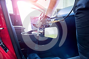 A car service worker cleans interiror with a special foam generator