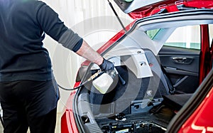 A car service worker cleans interiror with a special foam generator