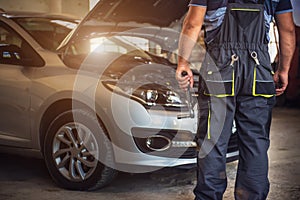 Car service worker diagnoses car breakdown