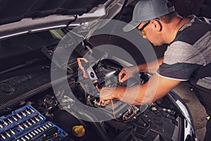 Car service worker diagnoses car breakdown