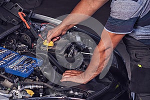 Car service worker diagnoses car breakdown