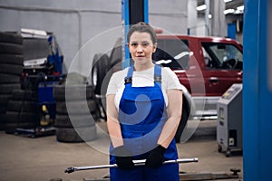 Car service worker mechanic holding tools and posing