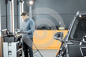 Car service worker preparing for vehicle body detailing