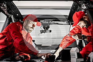 Car service workers disassembling car interior