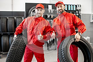Car service workers with new tires at the shop