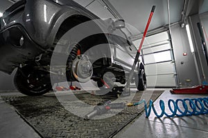 Car servise lifting car and changing wheels using trolley jack. A spring hose to a pneumatic tool. Tire repair, wheel replacement