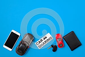 Car sharing concept. Composition with driver`s license, vehicle key, toy cars, text sign