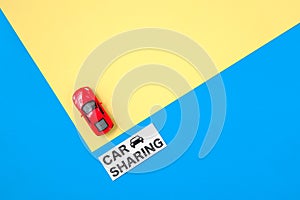 Car sharing concept. Red toy car model and text sign