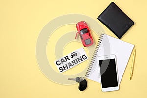 Car sharing service concept. Red toy car, agreement, vehicle key, smartphone, auto driver license and text sign