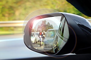 Car side mirror view with sunlight glare