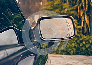 Car Side Mirror or Wing Mirror on Green Tree Background in Vintage Tone