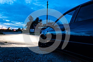 Car side view from behind. polished car. night. headlights light