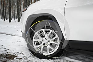 Car with snow chain on tire, closeup.
