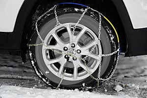 Car with snow chain on tire, closeup