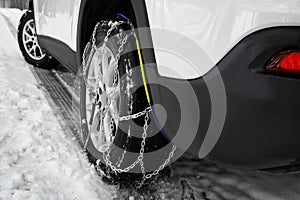 Car with snow chain on tire, closeup