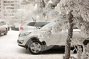 Car in the snow. snowy winter. parking car near the house. light machine and windscreen washer up from the frost. wrestling with s