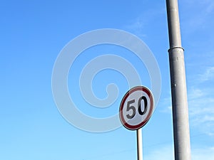 Car speed limit sign on blue sky background