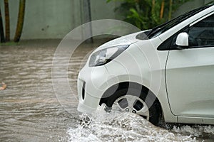 Car splashes through a large puddle on a flooded street