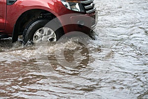 Car splashes through a large puddle on a flooded street