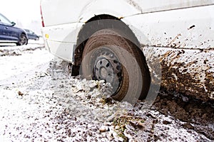 The car stalled in the mud in winter. minivan stalled in the mud. wrong, bad wheel tread for off road