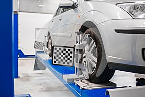 Car on stand with sensors wheels for alignment camber check in workshop of Service station.