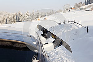 Women,s legs in snowboard from the car near beauty view of mountains and christmas trees in winter