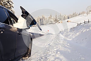 Women,s legs in snowboard from the car near beauty view of mountains and christmas trees in winter