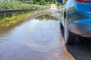 Car stands on flooded and closed road