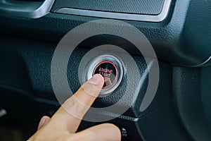 Car start stop system with finger pressing the button.finger pressing the Engine start stop button of a car