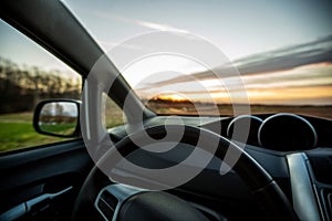 Car steering wheel interior at sunset. Traveling with car concept . Car insurance concept