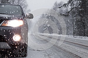 The car stopped at the curb during snowfall