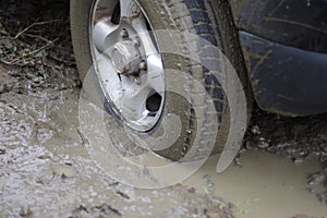 Car stuck, car wheel in a dirty puddle, rough terrain