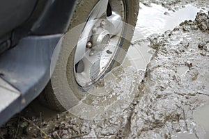 Car stuck, car wheel in a dirty puddle, rough terrain