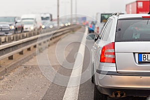 Car stucked in traffic jam on full road from back view.