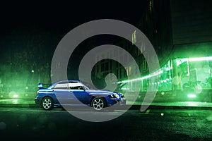 Car Subaru Impreza WRX stand in Moscow city near modern buildings at night