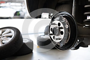 car suspension & bearing of wheel hub in auto service maintenance. Car lift up by hydraulic, waiting for tire replacement in