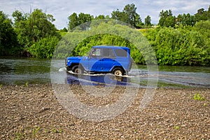 Car SUV UAZ rides on the river