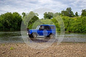 Car SUV UAZ rides on the river
