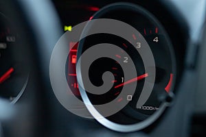 Car tachometer close-up. The arrow indicates low engine speeds