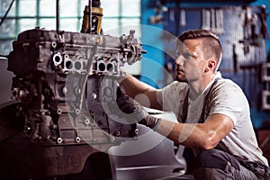 Car technician maintaining automotive engine photo