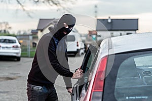 Car thief entering the vehicle and stealing a car.